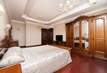 Luksusowa sypialnia z drewnianymi meblami, żyrandolami i elegancką pościelą