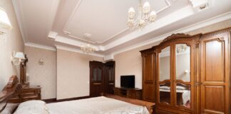 Luksusowa sypialnia z drewnianymi meblami, żyrandolami i elegancką pościelą