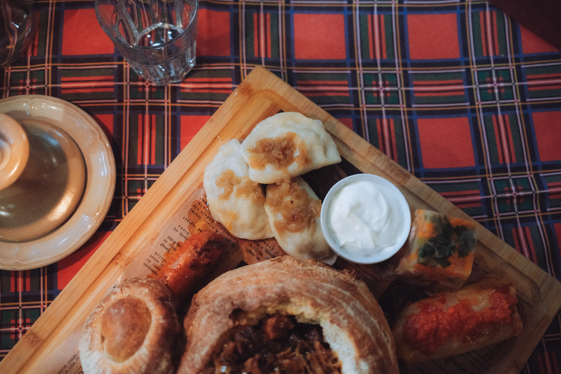 Polski obiad: pierogi, zupa w chlebie i gołąbki na drewnianej desce