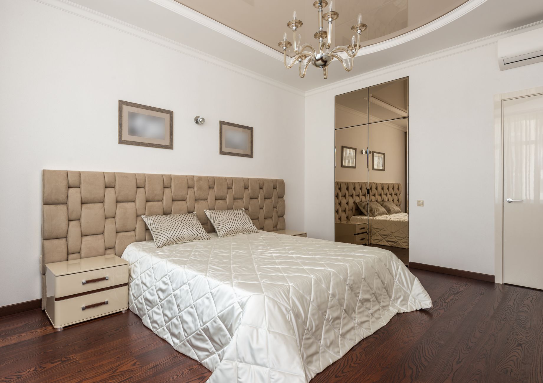 Sypialnia w stylu glam z żyrandolem i lustrzanymi drzwiami szafy