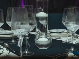 Eleganckie nakrycie stołu z kieliszkami i pływającymi świecami