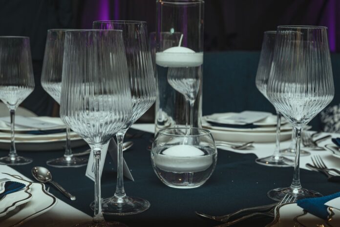 Eleganckie nakrycie stołu z kieliszkami i pływającymi świecami