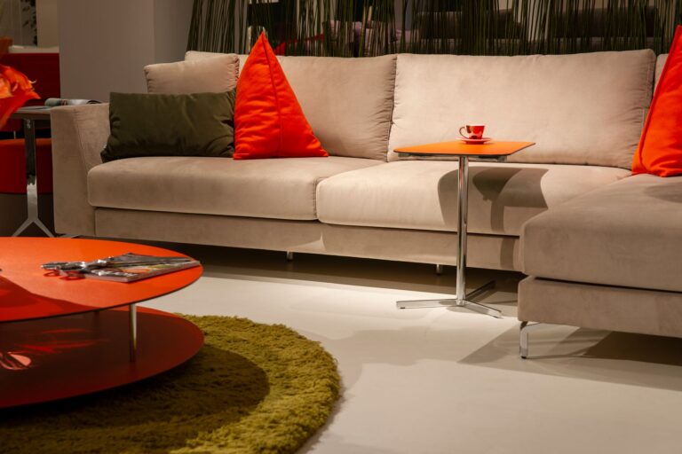 Beżowa sofa z czerwonymi poduszk
