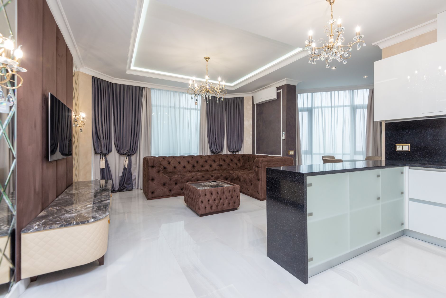 Przestronny nowoczesny salon z żyrandolami i elegancką sofą